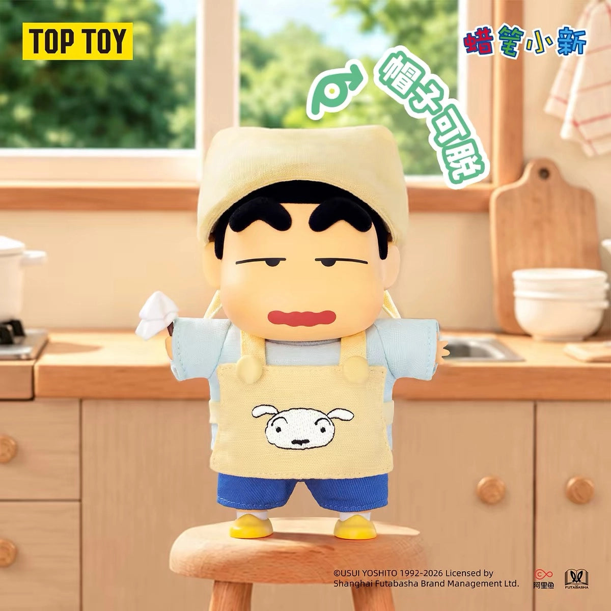「お掃除のお手伝い」スタイルのクレヨンしんちゃんぬいぐるみチャーム。頭に黄色いタオルを巻き、シロの顔が描かれたエプロン姿で小さなはたきを持っている様子。